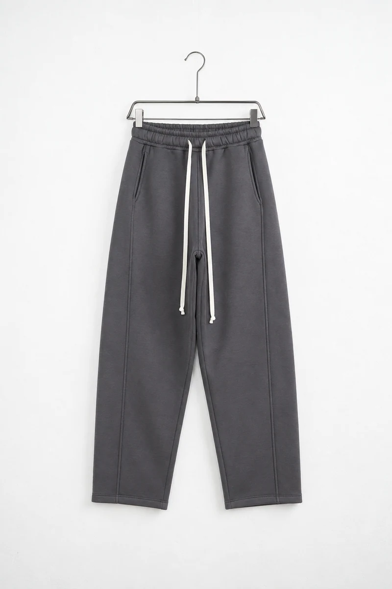 Pantaloni baggy felpați bărbați gri antracit; vedere frontală pe umeraș pentru compararea croielii.
