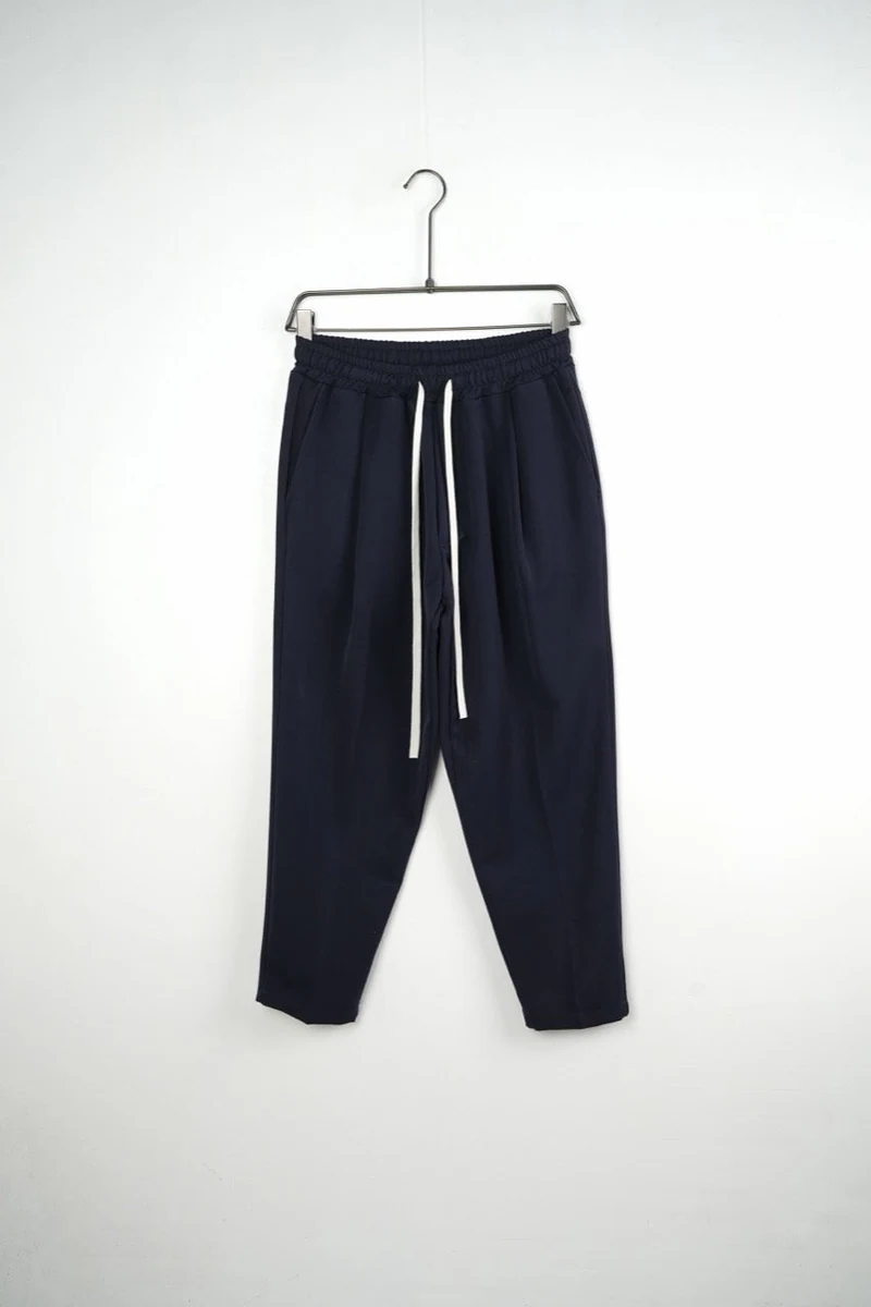 Pantaloni bărbați bleumarin carrot fit; vedere frontală pe umeraș pentru compararea croielii.