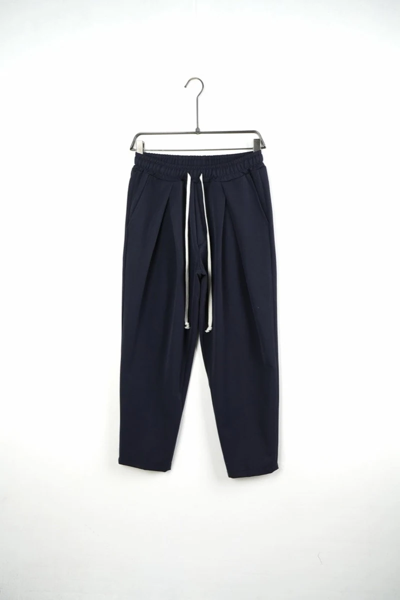 Pantaloni bărbați bleumarin cu pense și talie elastică — vedere frontală pe umeraș.