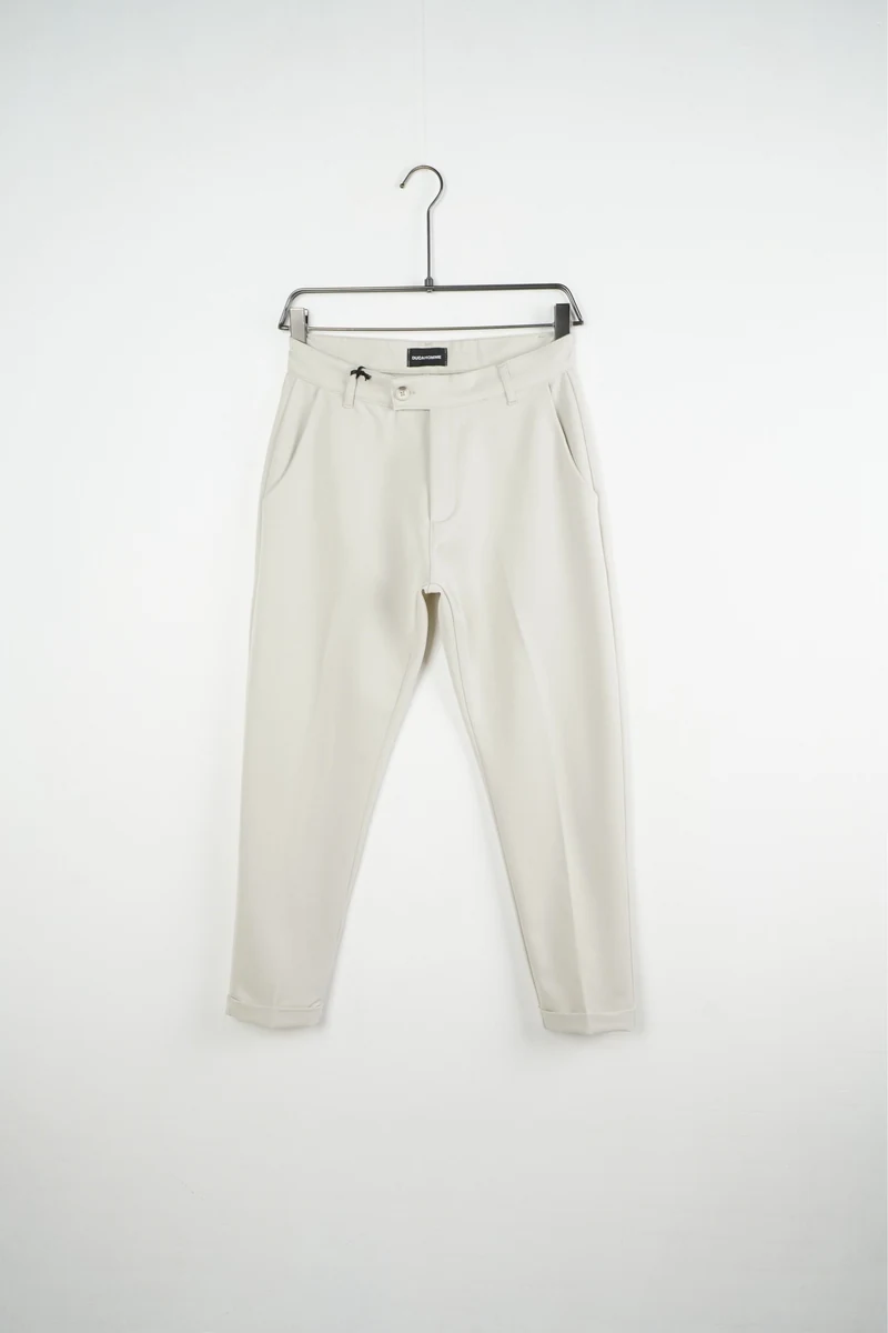 Pantaloni bărbați crem slim fit; vedere frontală pe umeraș pentru compararea croielii.
