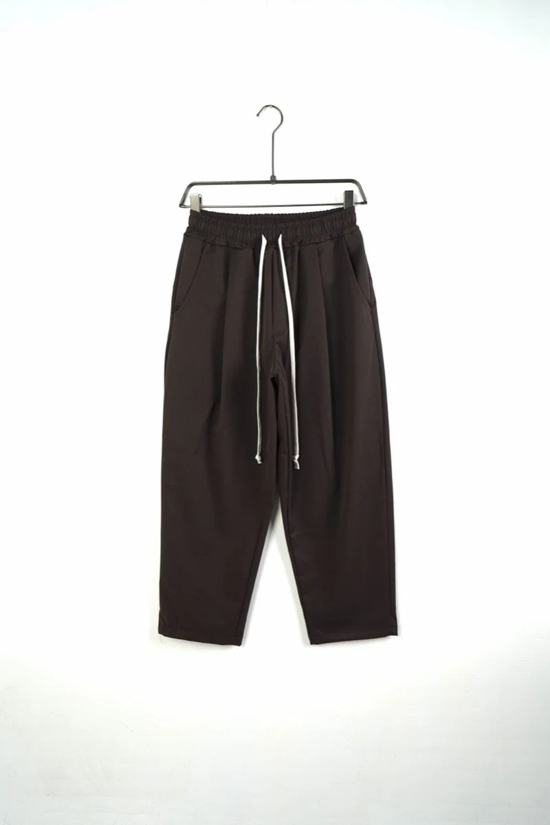 Vedere frontală pe umeraș a modelului: pantaloni bărbați maro cu talie elastică și șnur.