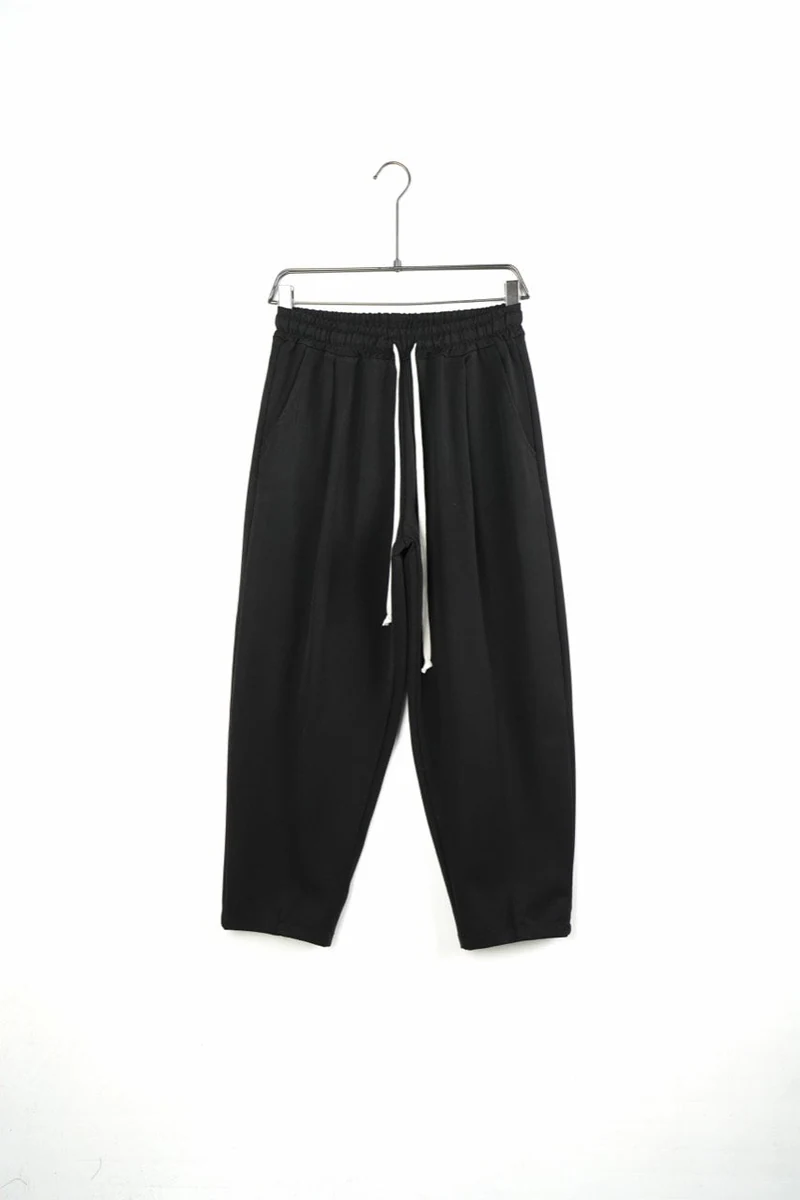 Pantaloni bărbați negri largi baggy — vedere frontală pe umeraș.