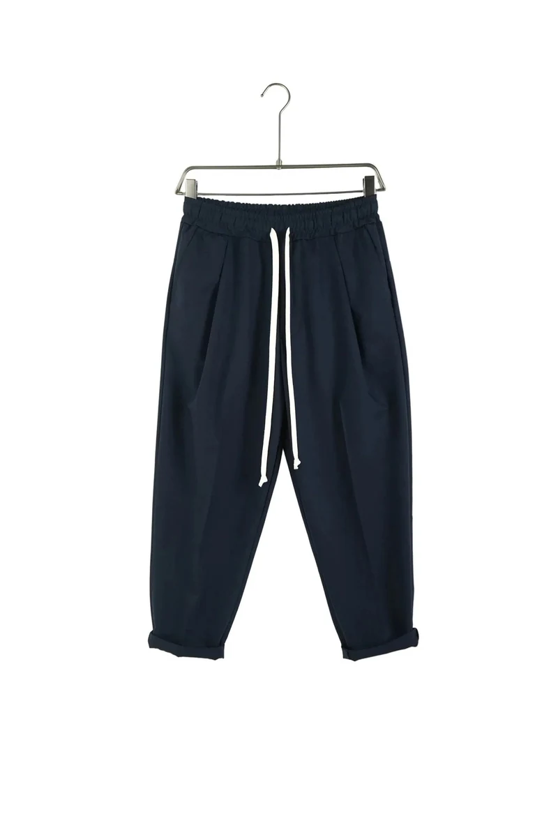 Imagine de prezentare: pantaloni bleumarin ușor slim cu șnur lung și nasturi la spate; vedere frontală pe umeraș.