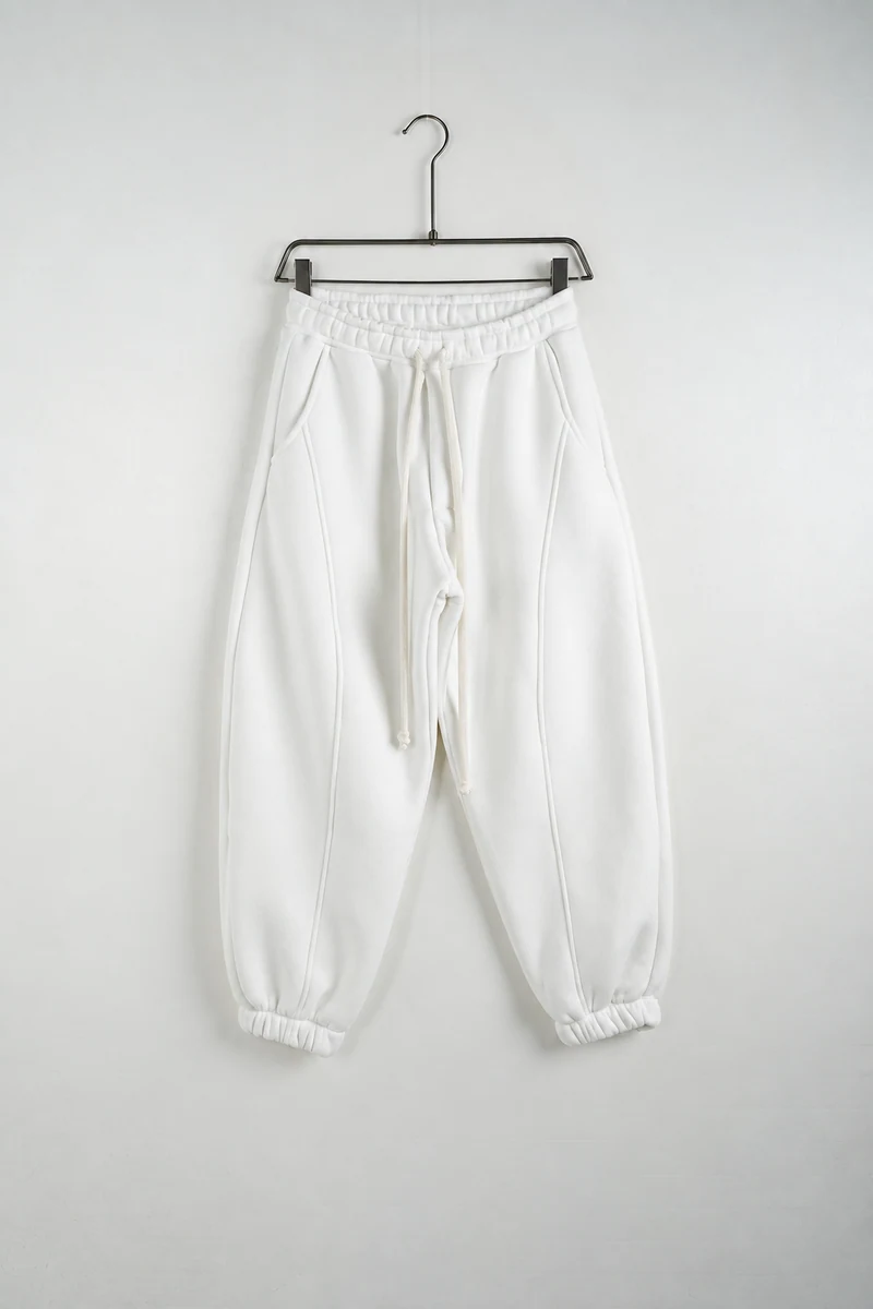 Vedere frontală pe umeraș: pantaloni jogger balloon fit bărbați albi.
