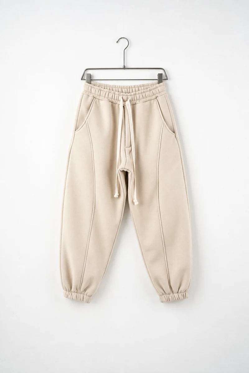 Pantaloni jogger balloon fit bărbați bej, vedere frontală pe umeraș, în catalogul editorial.