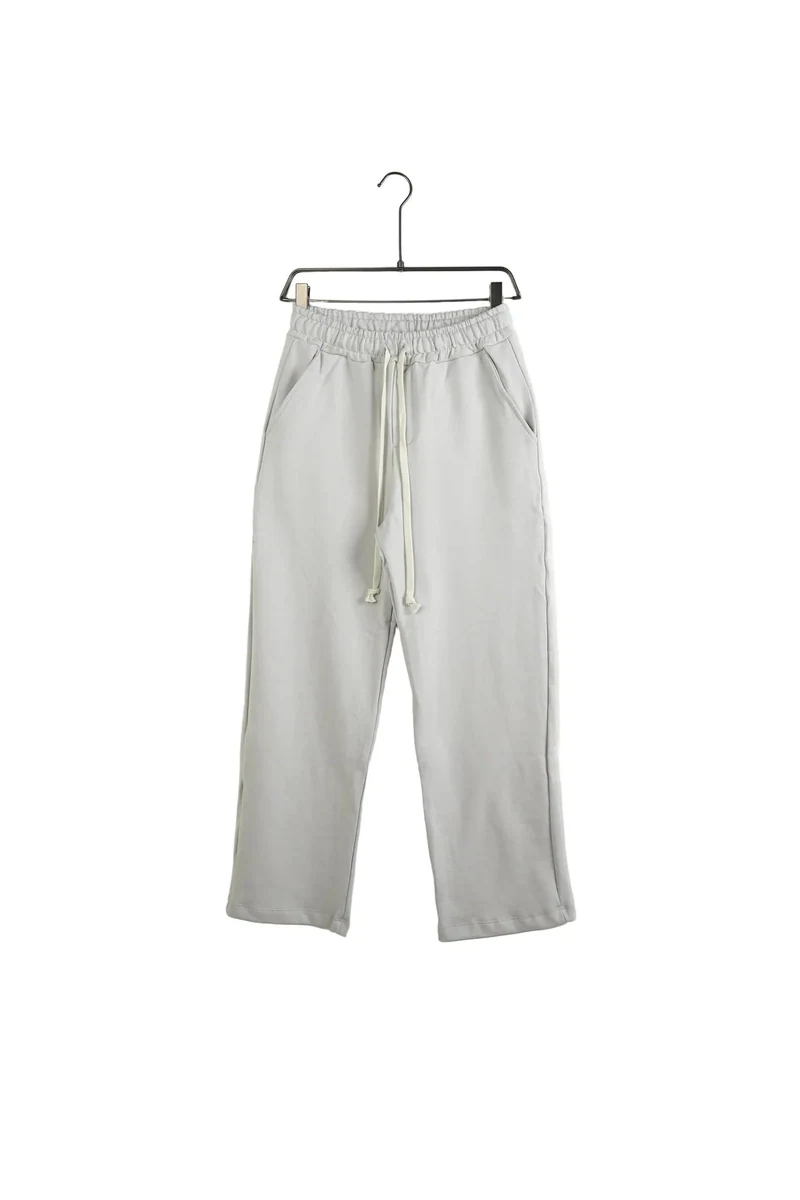 Pantaloni largi gri deschis de trening pentru bărbați — vedere frontală pe umeraș.