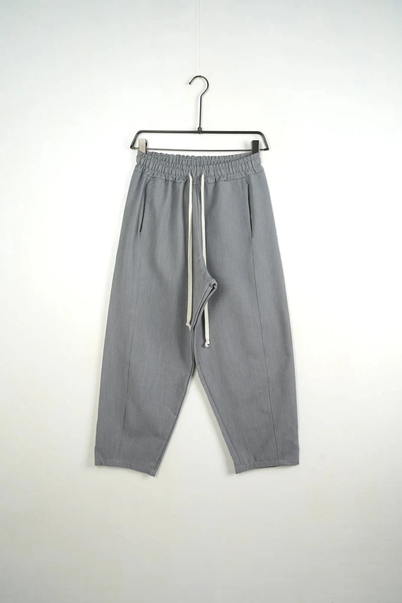 Vedere frontală pe umeraș a modelului: pantaloni lungi largi bărbați casual gri cu șnur.