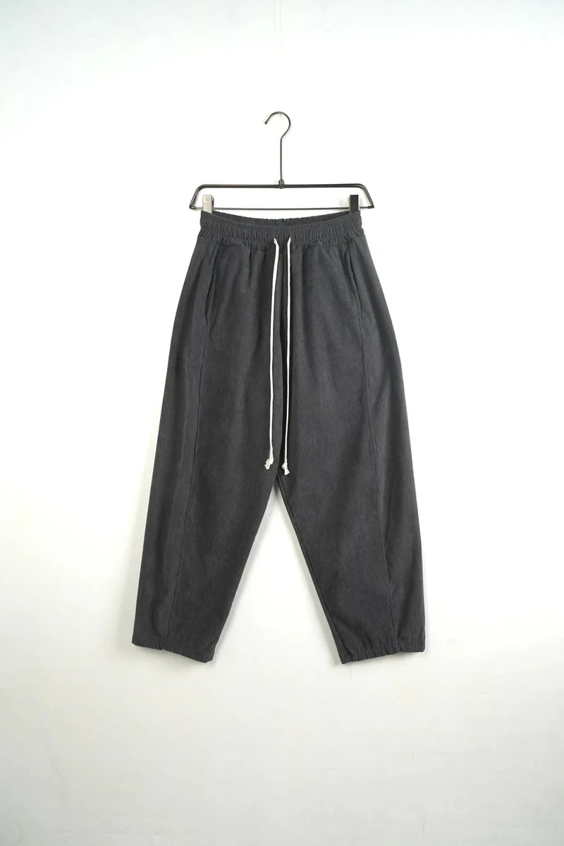 Pantaloni lungi largi bărbați gri inchis cu dungi și șnur lung; vedere frontală pe umeraș pentru compararea croielii.