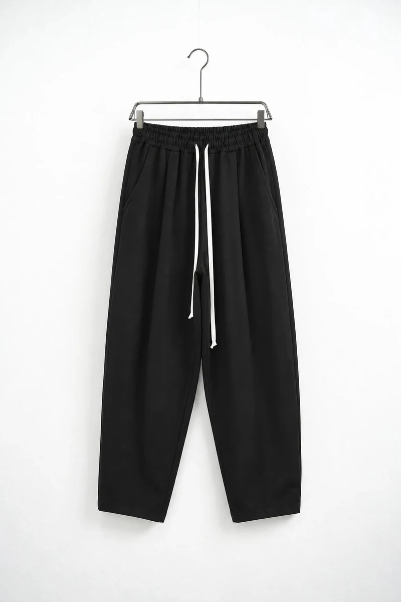 Pantaloni lungi ușor slim bărbați negru cu șnur lung și buzunar la spate; vedere frontală pe umeraș pentru compararea croielii.