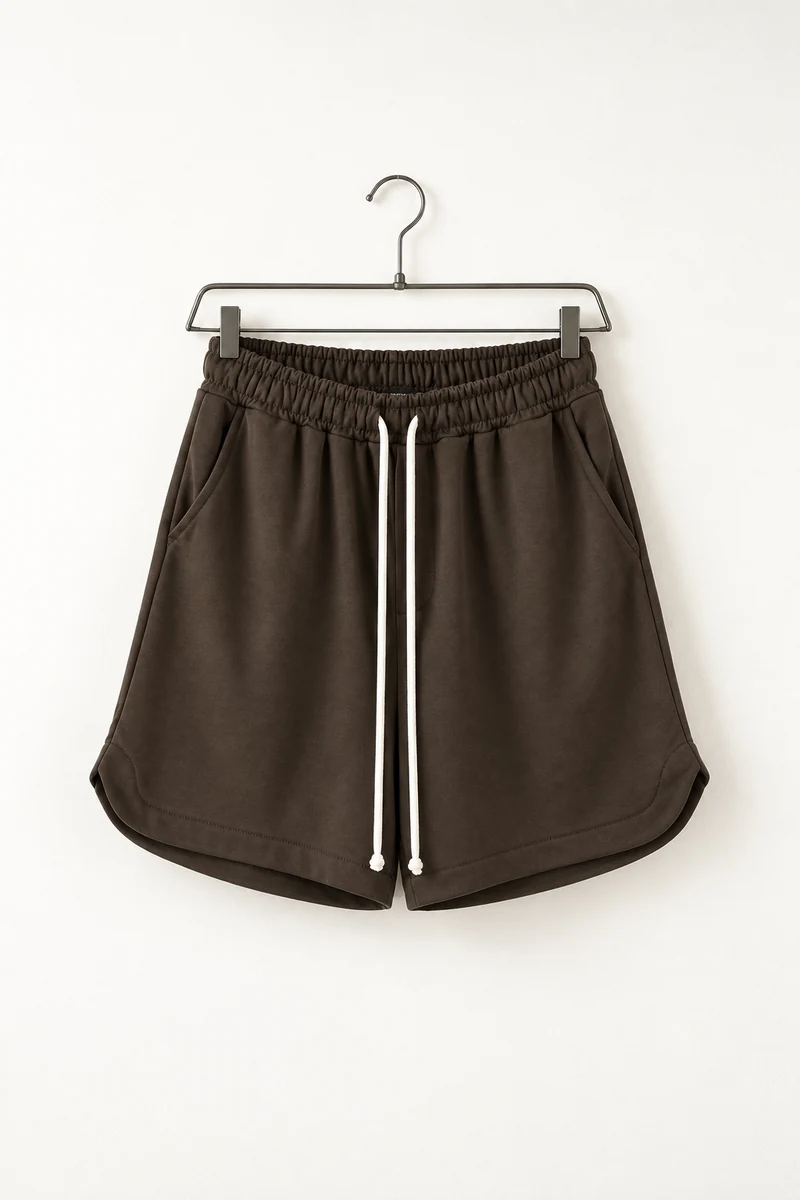 Vedere frontală pe umeraș: pantaloni scurți sport maro cu șnur lung și despicătură laterală.