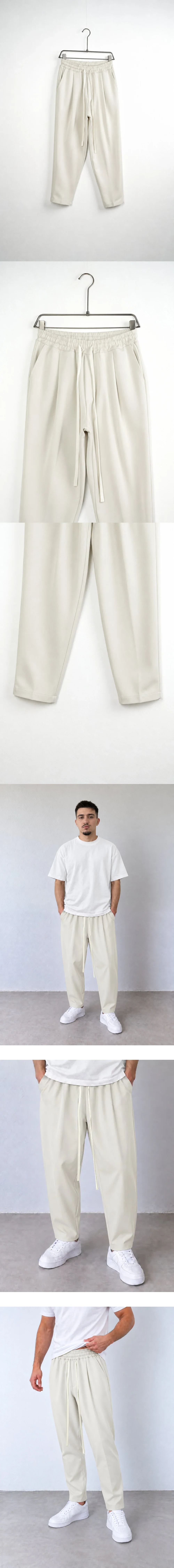 Pantaloni Bărbați Crem Carrot Fit — pantaloni pe umeraș metalic, vedere ușor oblică — cadrul 2 din galeria editorială.