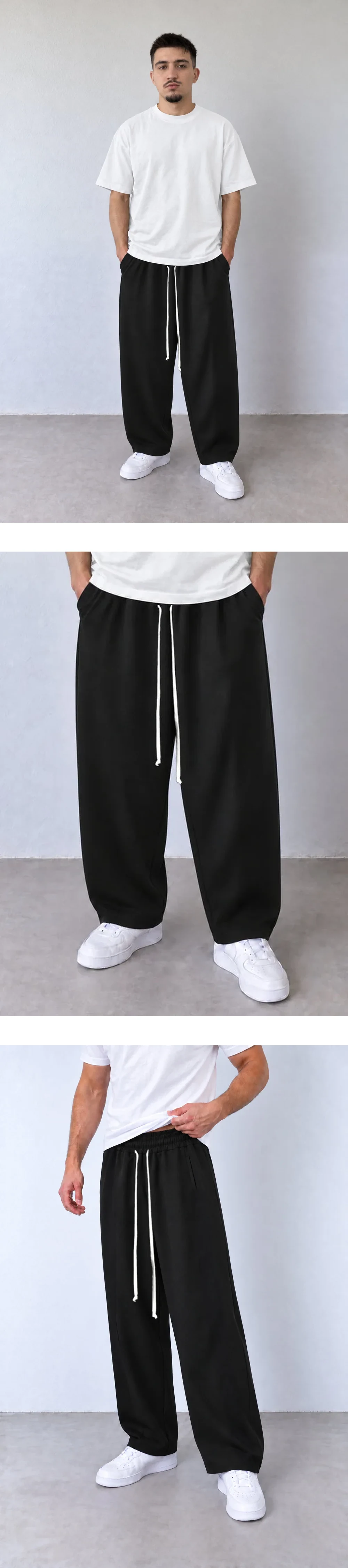 Pantaloni Bărbați Negri Baggy cu Cusături Frontale — pantaloni baggy negri 202501-INV pentru bărbați, vedere frontală pe model cu tricou alb și șnur lung — cadrul 2 din galeria editorială.