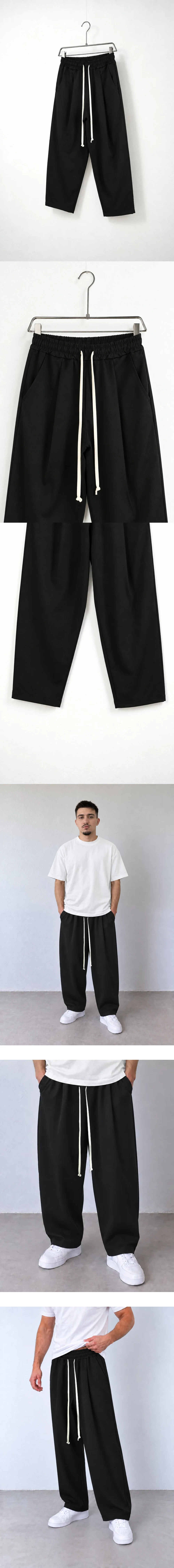 Pantaloni Bărbați Negri cu Talie Elastică și Șnur — pantaloni pe umeraș, vedere oblică — cadrul 2 din galeria editorială.