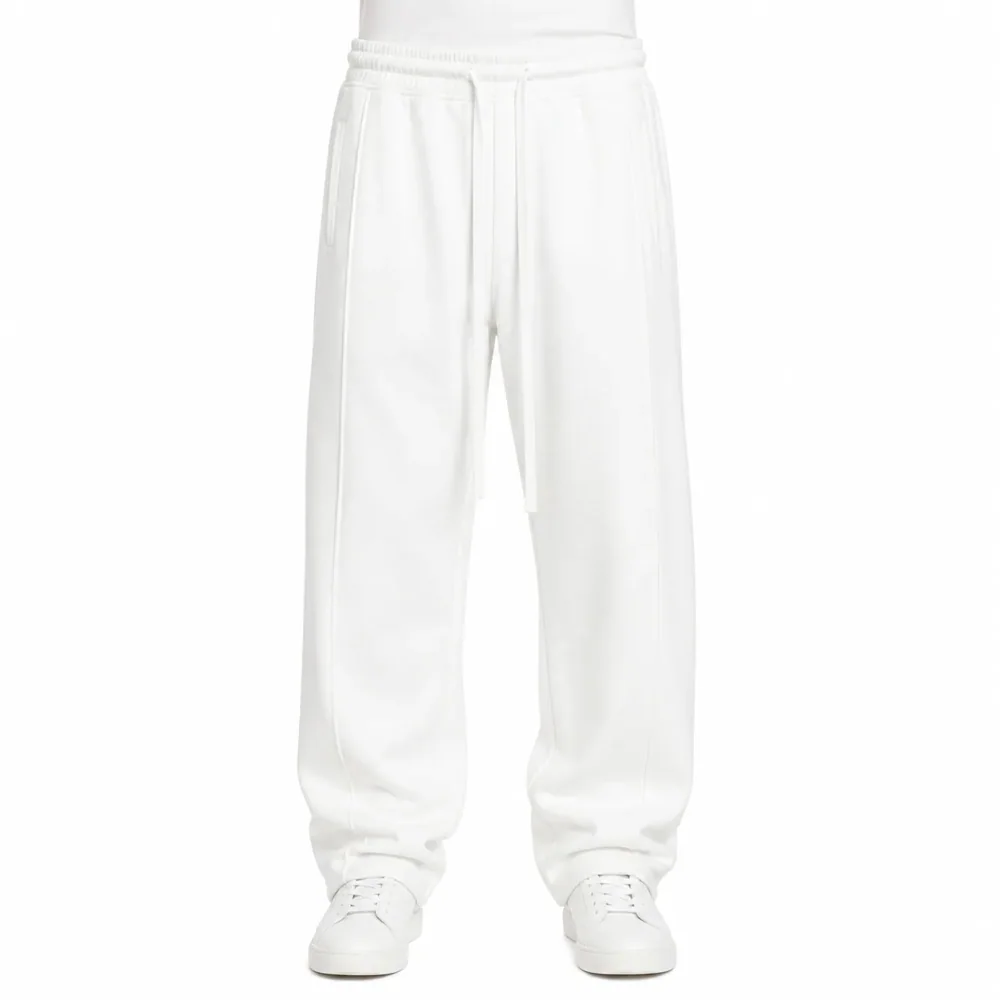 Pantaloni de Trening Bărbați Albi Baggy Fit din Bumbac — pantaloni bărbați albi baggy fit cu sneakers albi pe model — cadrul 2 din galeria editorială.