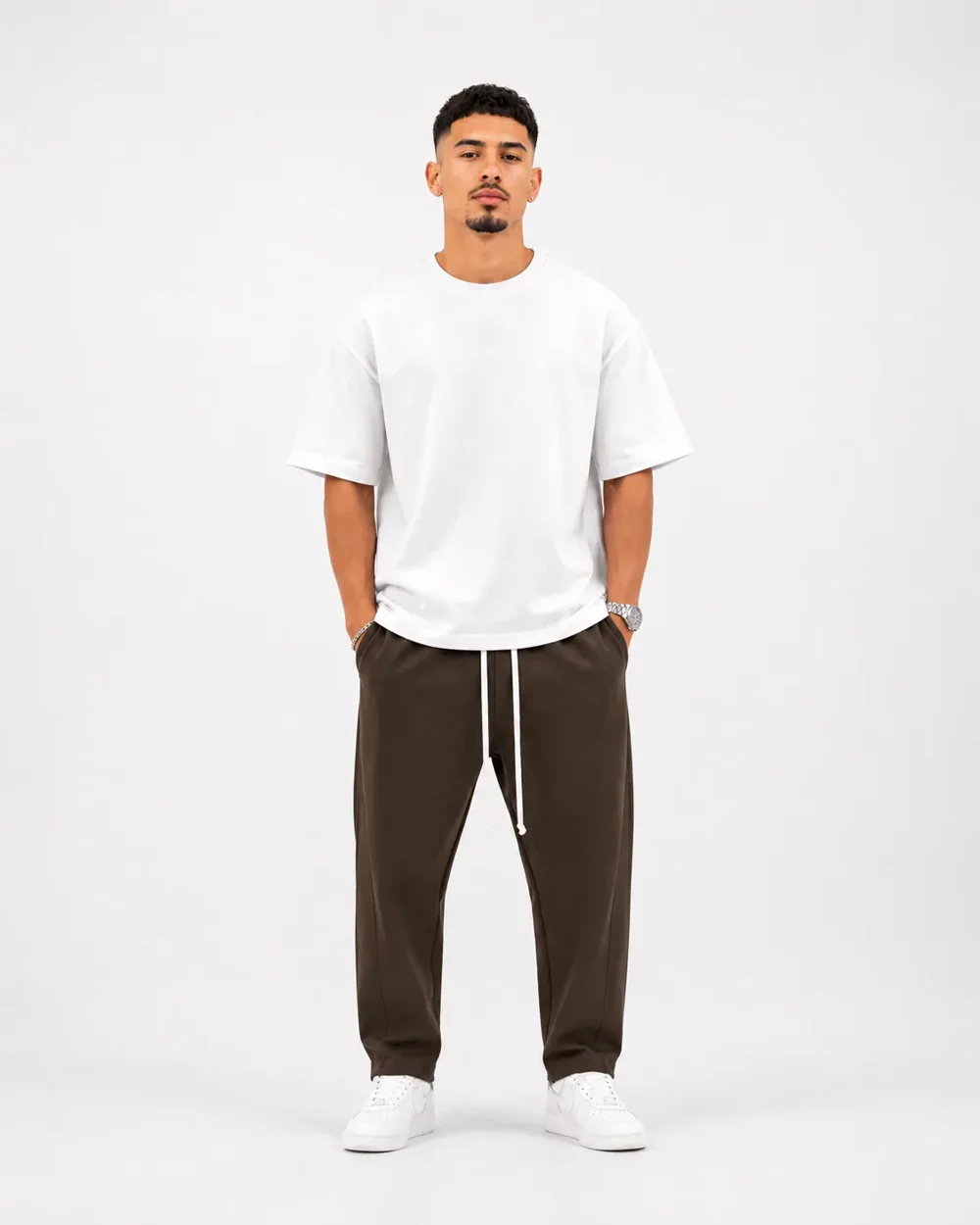 Pantaloni lungi largi bărbați casual maro cu șnur — ședință foto studio pentru pantaloni maro premium streetwear asortați cu tricou alb oversized și pantofi sport albi, stil mod — cadrul 2 din galeria editorială.
